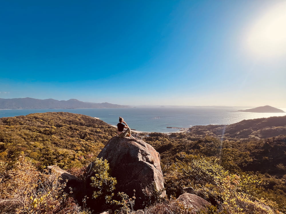 Standing atop Tateishi Mountain, taking in the breathtaking view of the surrounding landscape and feeling the refreshing breeze.